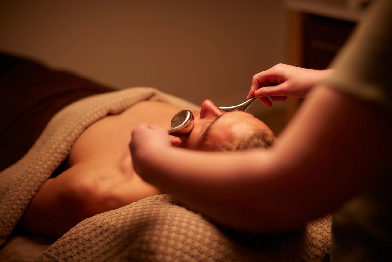 Man having a facial with smooth metal probes.